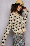 Cream and black floral crochet cardigan with tassel hem, loose fit, textured openwork fabric.