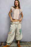 Pink cropped t-shirt with floral patches and lace trim, ruffled hem, loose fit, soft fabric texture