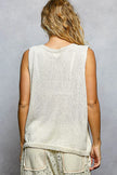 Cream knitted sleeveless top with textured knit and round neckline worn by woman