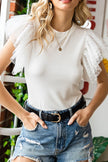 White ribbed blouse with ruffled cap sleeves, round neck, distressed denim shorts.