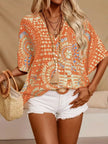 Orange patterned v-neck top with loose fit, textured polyester blend and layered bead necklace.