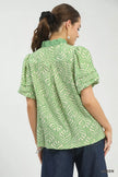 Soft green leaf-print blouse with ruffle neck and puff sleeves