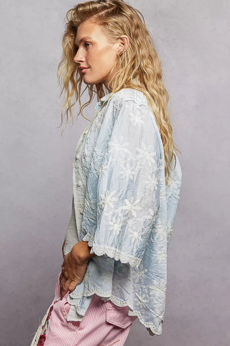 Buttoned placket detail on a floral embroidered shirt