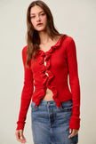 Red ribbed knit cardigan with cascading ruffles, fitted waist, denim skirt.