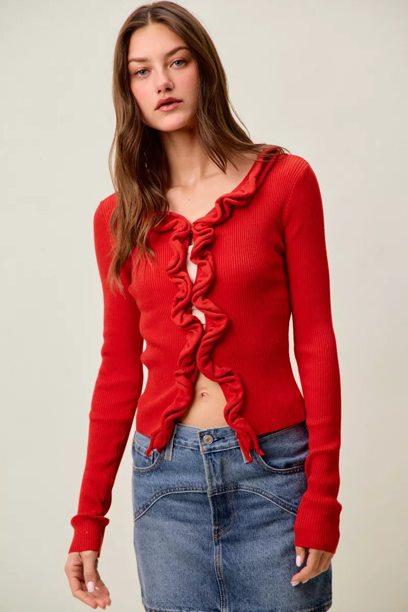 Red ribbed knit cardigan with cascading ruffles, fitted waist, denim skirt.