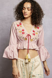 Light pink floral embroidered cropped blouse with flared ruffle sleeves and tassel tie closure.