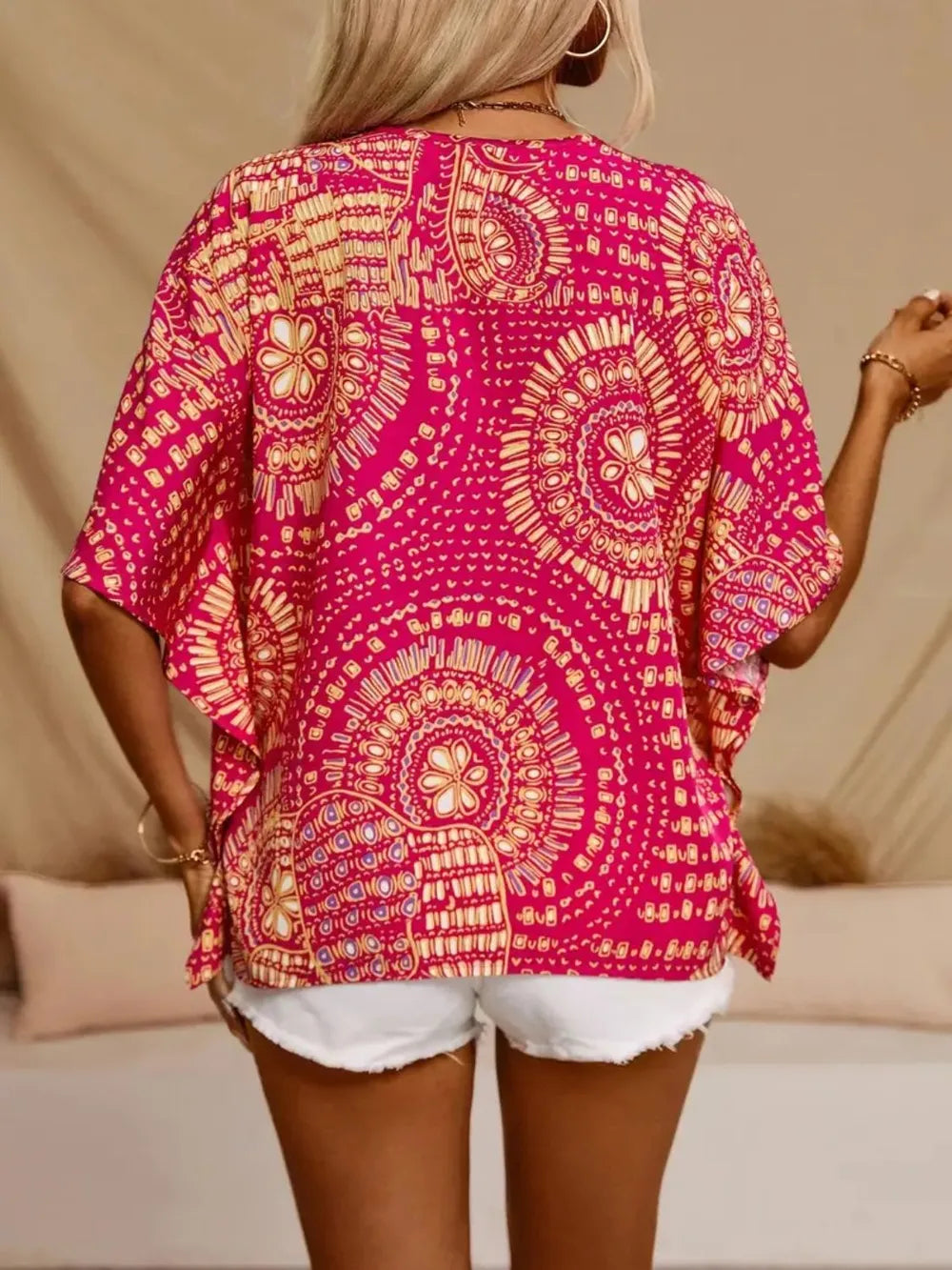 V-neck printed top in bold pink and gold, loose fit, polyester blend texture
