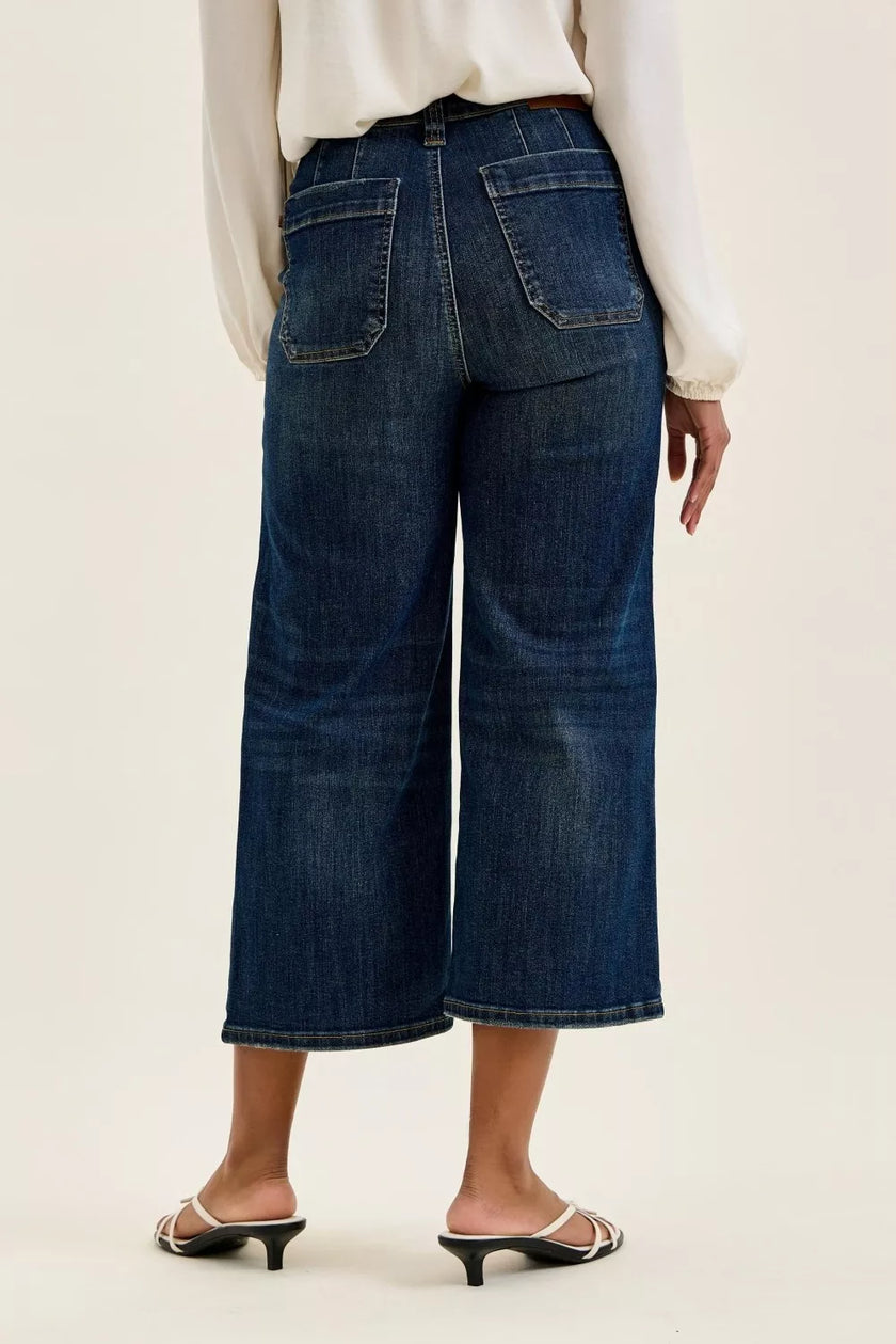 Dark indigo high-waisted wide-leg utility jeans with durable cotton blend, patch pockets, elongating fit, and classic distressed texture