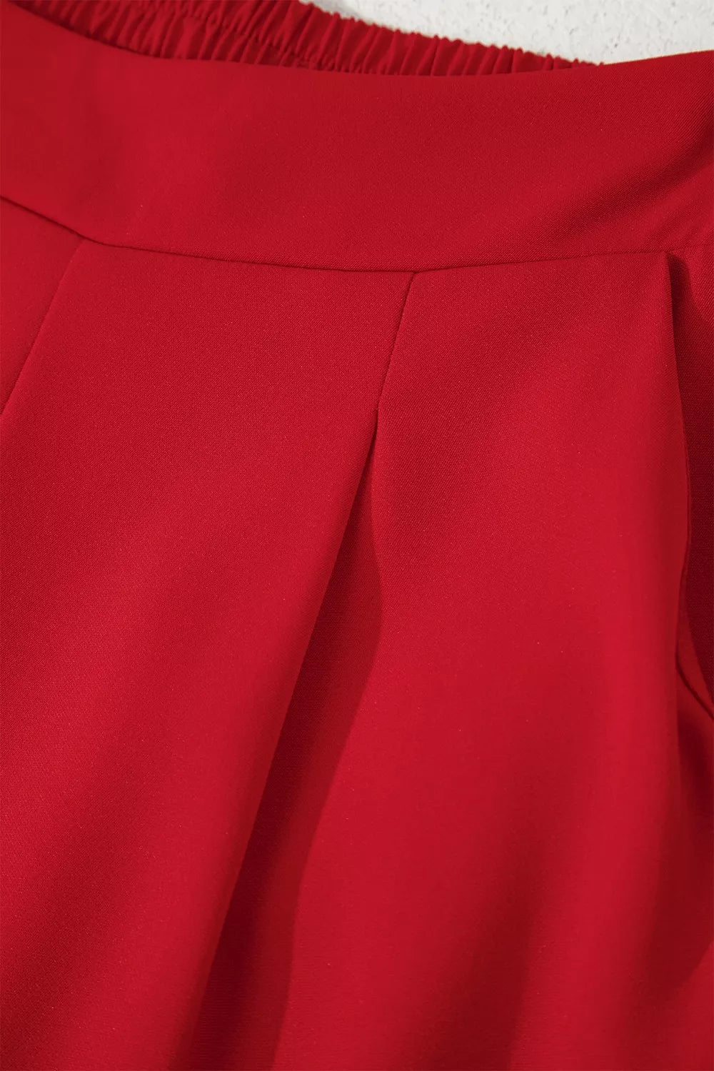 Black pleated straight leg pants folded flat