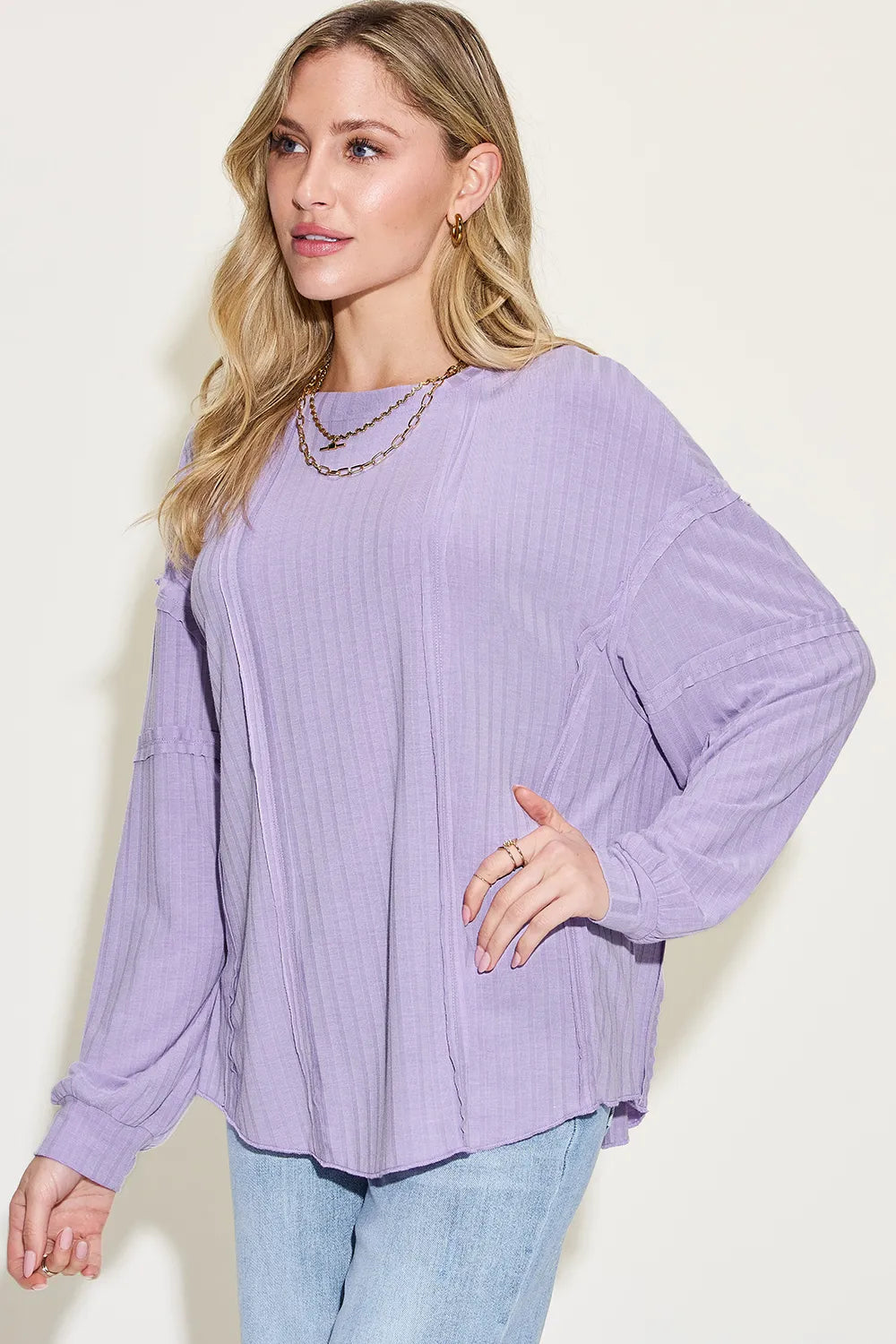 Model wearing ribbed long sleeve tshirt over fitted jeans