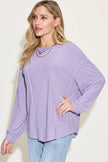 Model wearing ribbed long sleeve tshirt over fitted jeans