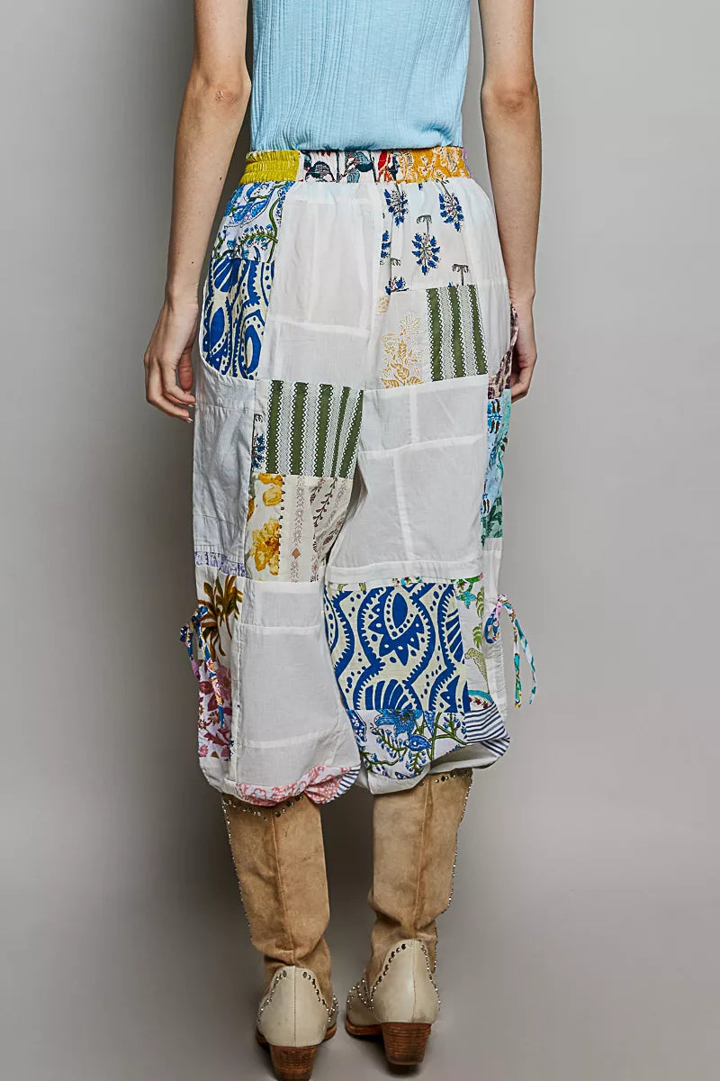White patchwork wide leg pants with blue floral prints and adjustable side drawstrings