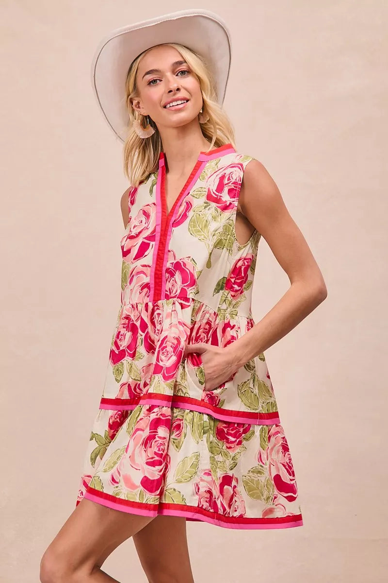 Front view of floral tiered mini dress in coral pink