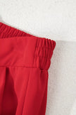 Light gray pleated pants on hanger showing pleats detail