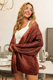 Copper metallic knit V-neck cardigan with relaxed fit and shimmering texture.