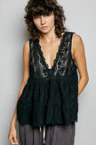 Black lace sleeveless top with deep V-neck, scalloped edges, and tiered ruffled hem on model