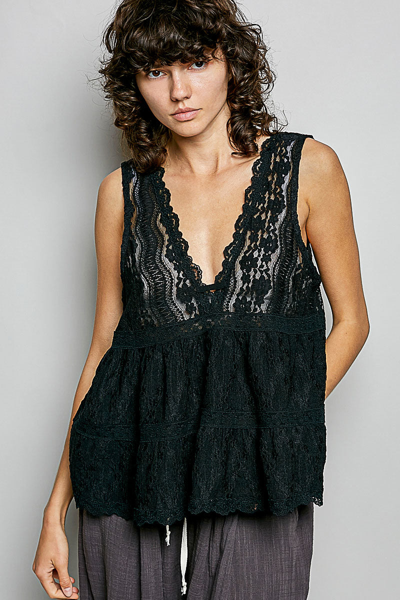 Black lace sleeveless top with deep V-neck, scalloped edges, and tiered ruffled hem on model