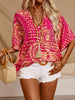 V-neck printed top in vibrant pink and gold, loose fit, polyester blend, tassel necklace accent.
