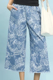Blue stone wash denim wide leg crop pants with white floral print frayed hem