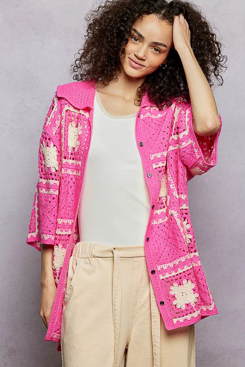 Close-up of floral crochet shirt showing intricate openwork details and button accents