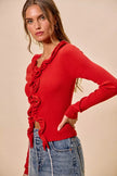 Red ribbed sweater with cascading ruffles, fitted long sleeves, denim pairing