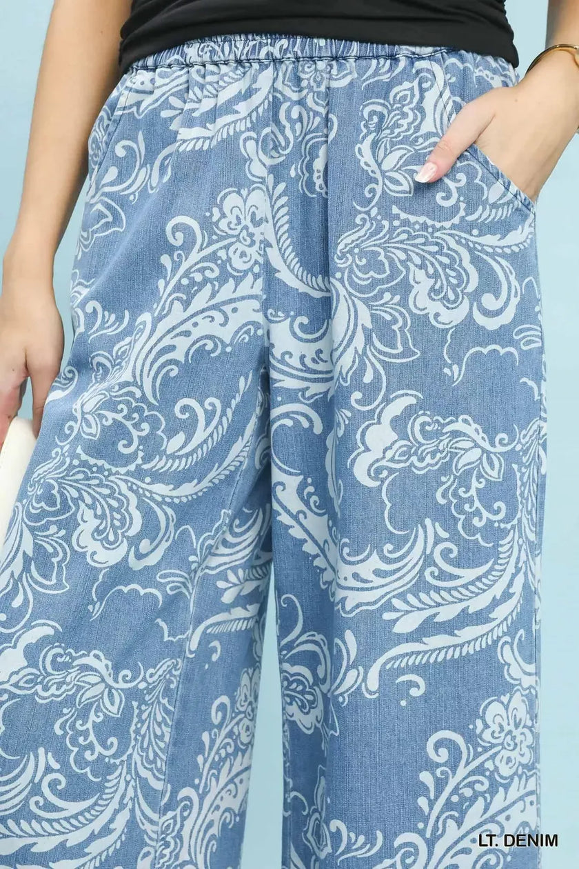 Light blue stone wash denim wide leg crop pants with white floral patterns