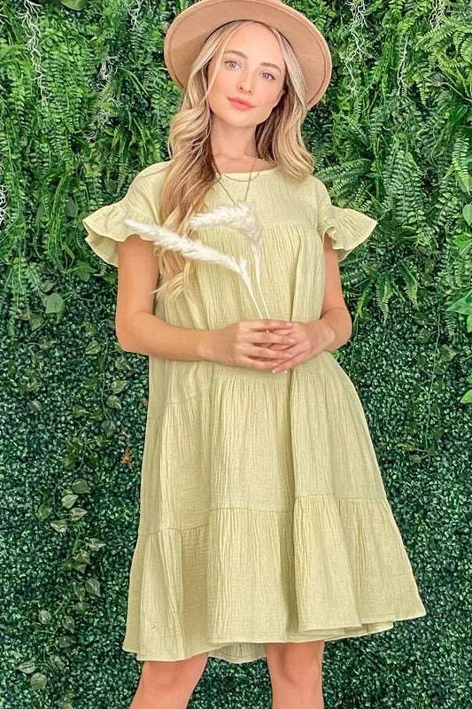Light green cotton gauze baby doll dress with ruffled tiered hem and short sleeves