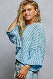 Sleeve detail of cropped sweater top with delicate openwork pattern