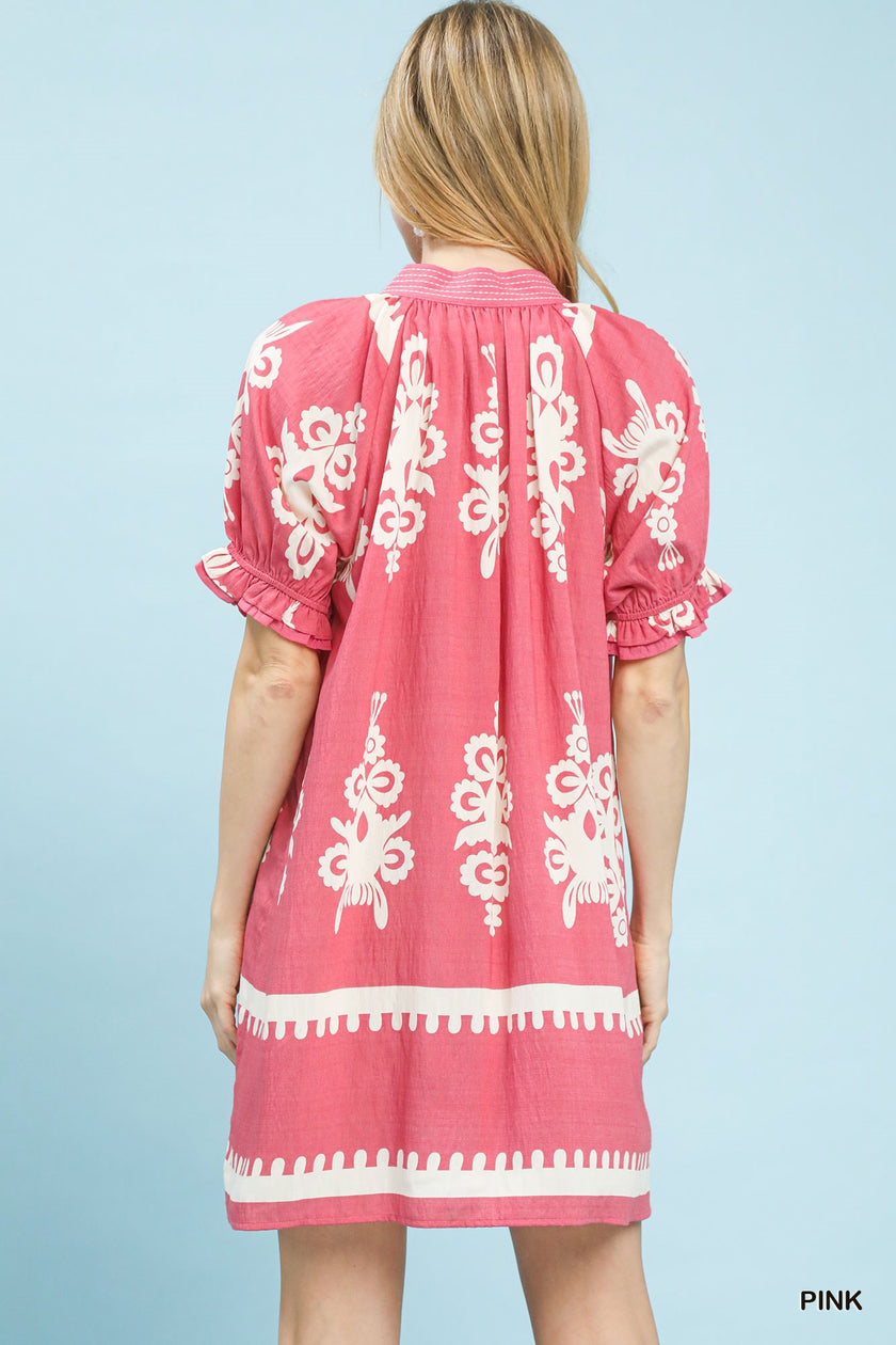 Back view of pink mini dress with white floral print, ruffled sleeves, and hem border.