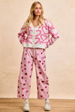 Pink textured heart cardigan with button closure, cropped fit, cozy knit fabric.