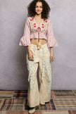 Woven pink cropped blouse with floral embroidery, flared ruffle sleeves, and tassel tie.