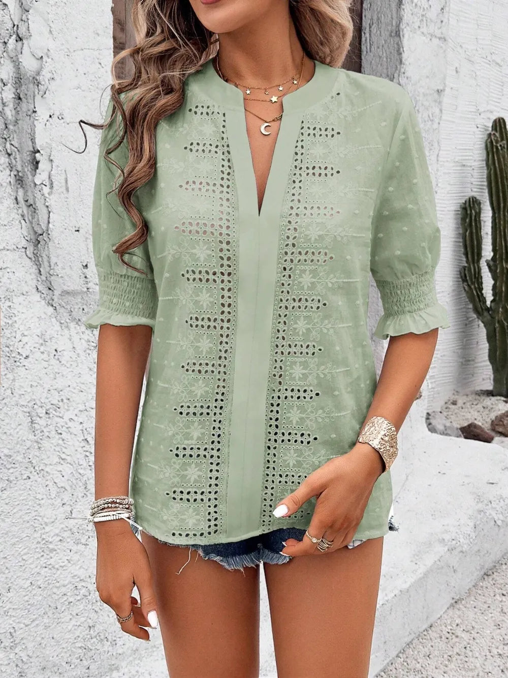 front view of white eyelet blouse highlighting notched neckline and delicate texture