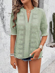 front view of white eyelet blouse highlighting notched neckline and delicate texture