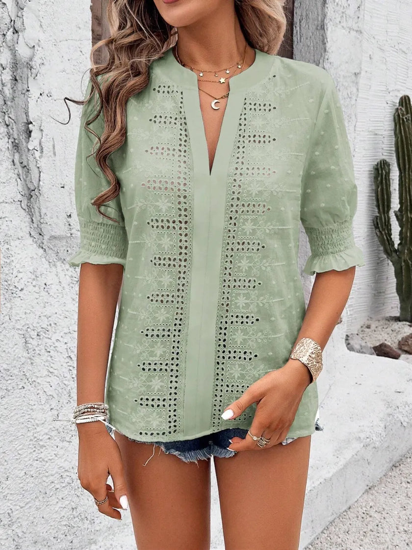front view of white eyelet blouse highlighting notched neckline and delicate texture