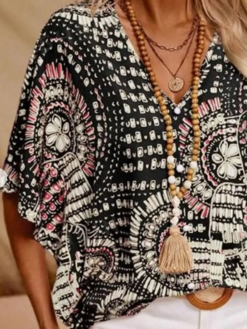 Black and white patterned V-neck top with pink accents, loose fit, polyester blend fabric.