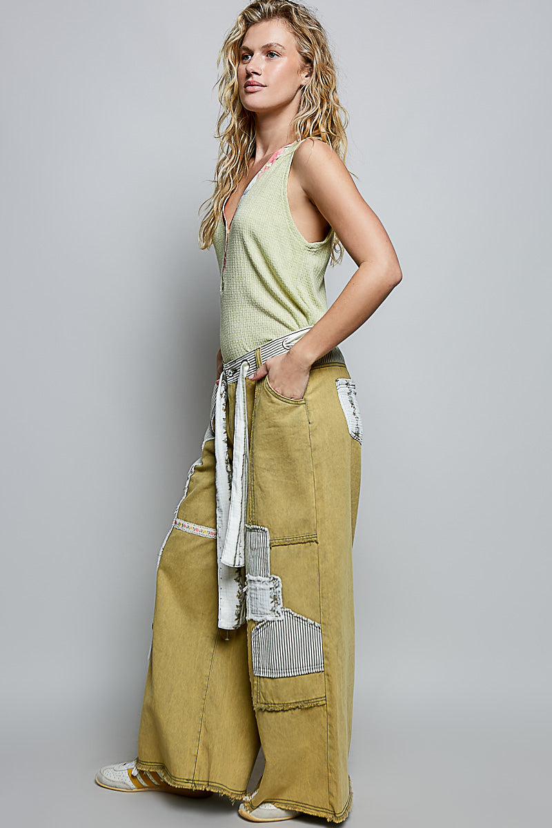 Woman wearing a light green ribbed v-neck tank top with floral contrast neckline