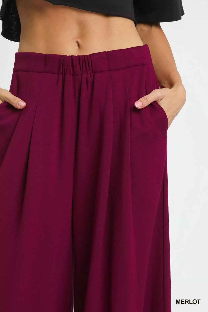 Wide-leg pants in merlot red displayed with clean modern lines