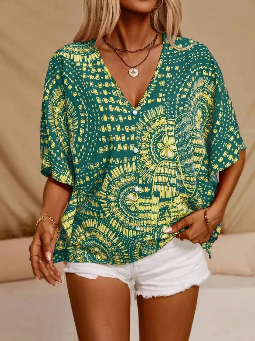 Green and yellow patterned V-neck blouse with button front and loose fit.