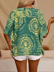 Green and yellow patterned V-neck top with loose fit, opaque polyester blend fabric.