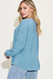 Model showcasing ribbed long sleeve tshirt with curved silhouette