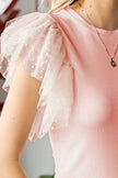 Pink ribbed blouse with white lace ruffled cap sleeves and round neck.