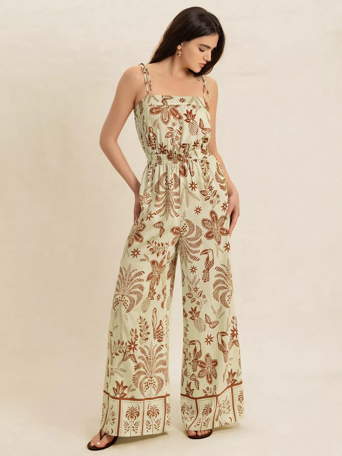 Light green tropical print wide leg jumpsuit with tie straps and smocked waist