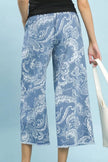 Blue stone wash floral wide leg crop pants with frayed hems and relaxed fit