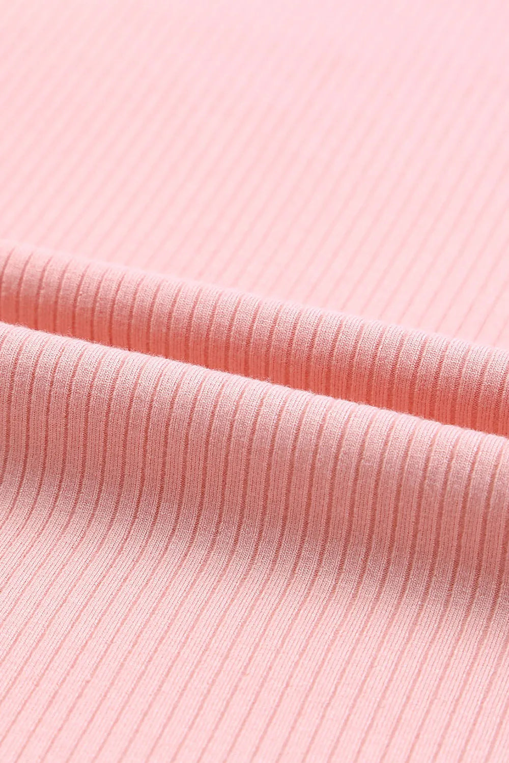 Soft pink ribbed knit ruffled round neck cap sleeve blouse close-up texture