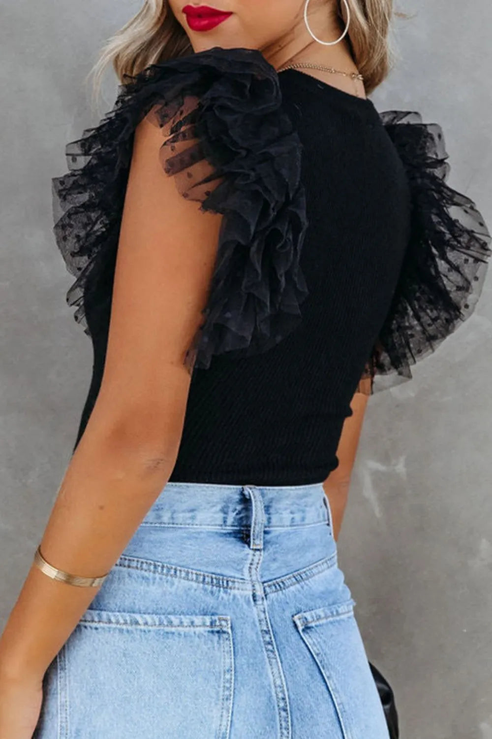 Black ruffled cap sleeve blouse with ribbed texture and fitted silhouette