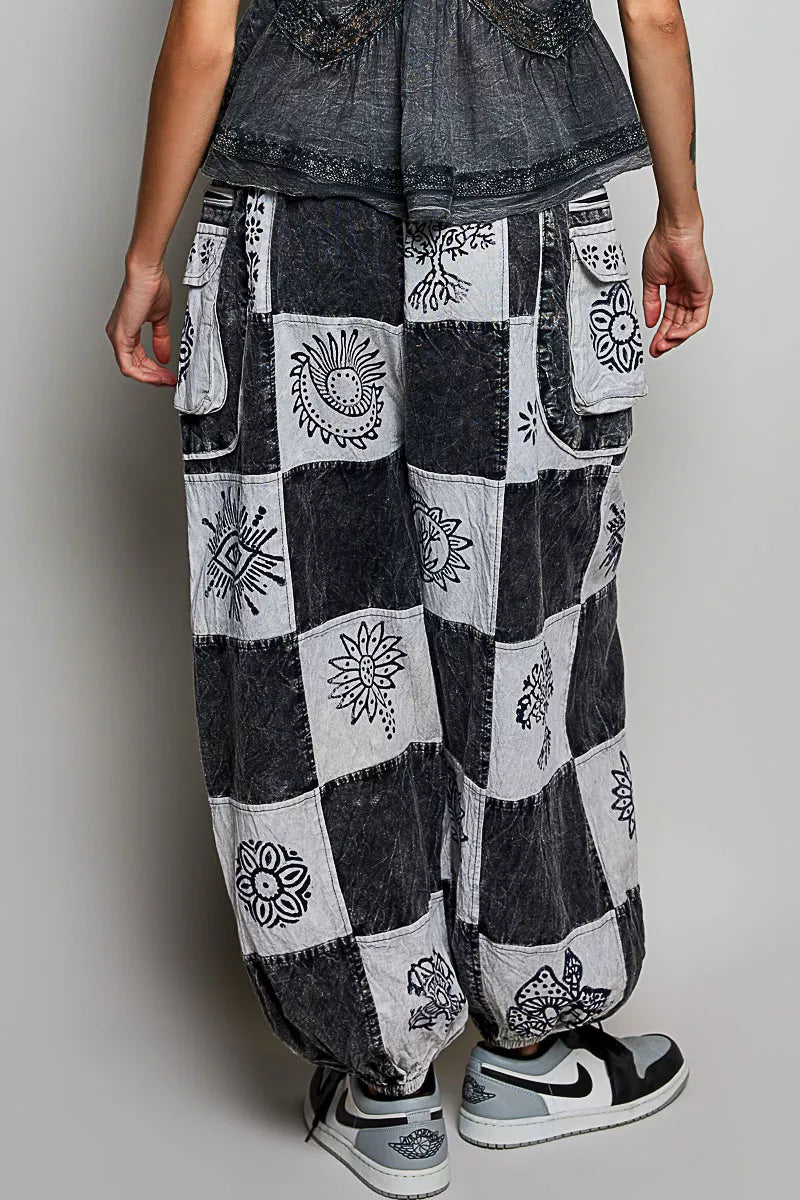 High-rise patchwork joggers with grey and black Aztec prints, drawstring waist, and cargo pockets