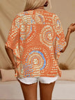 Orange paisley printed V-neck top with loose fit and textured polyester blend fabric.