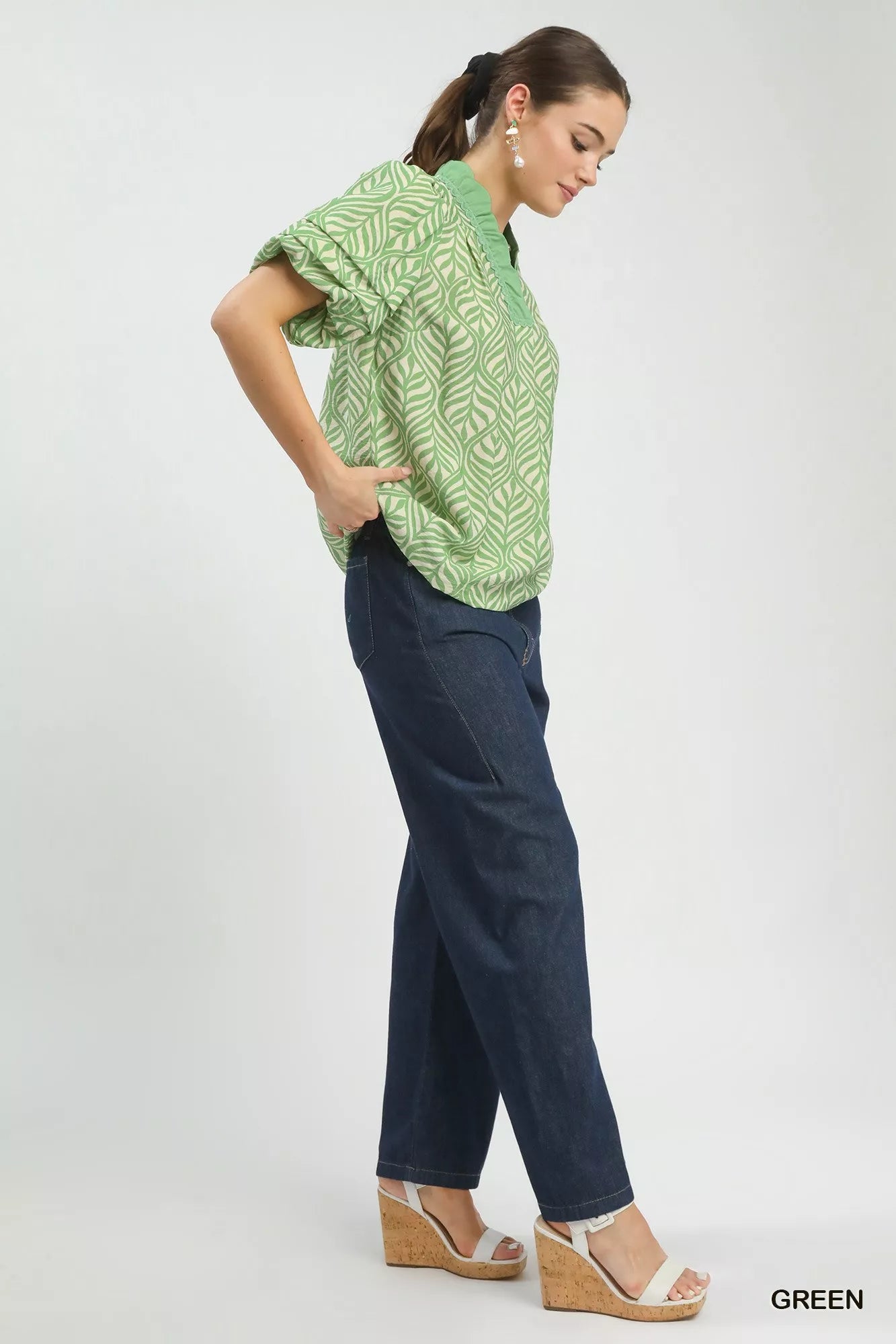 Leaf-patterned blouse paired with dark denim high-waisted pants