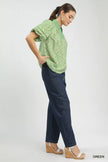 Leaf-patterned blouse paired with dark denim high-waisted pants