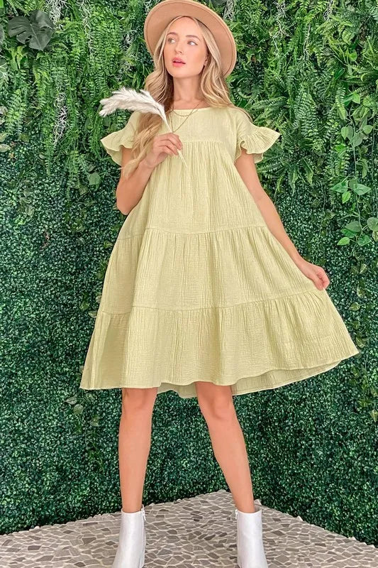 Lime green cotton gauze baby doll dress with ruffled tiered design and short sleeves